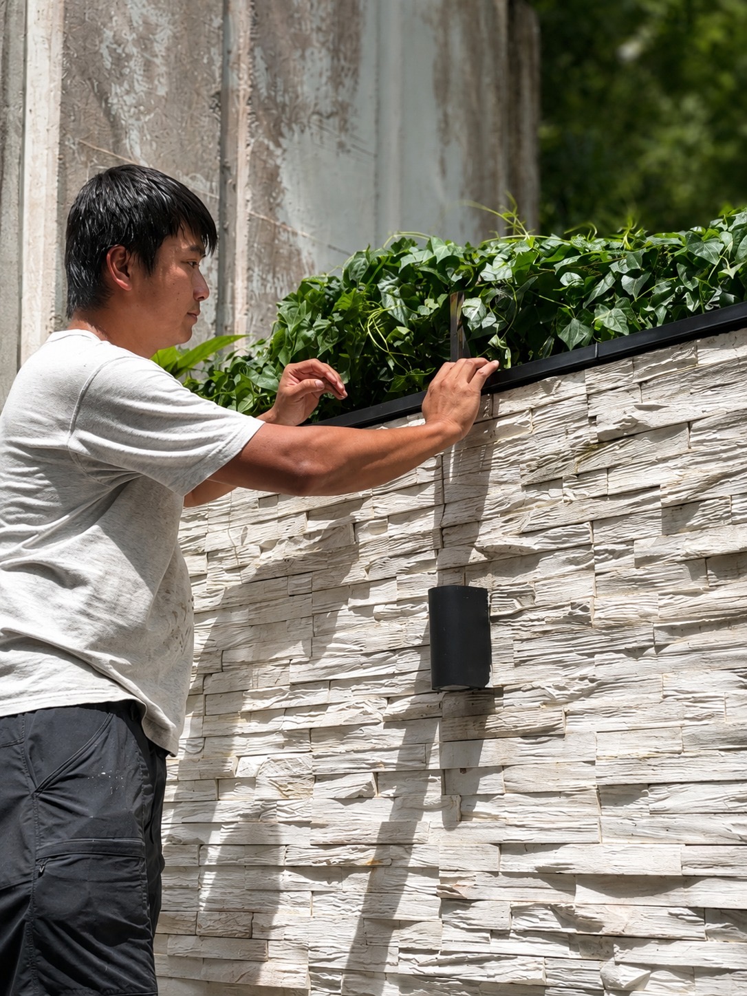 SecurePro installer positioning a wireless wall-top climb detection sensor without a perimeter cable route