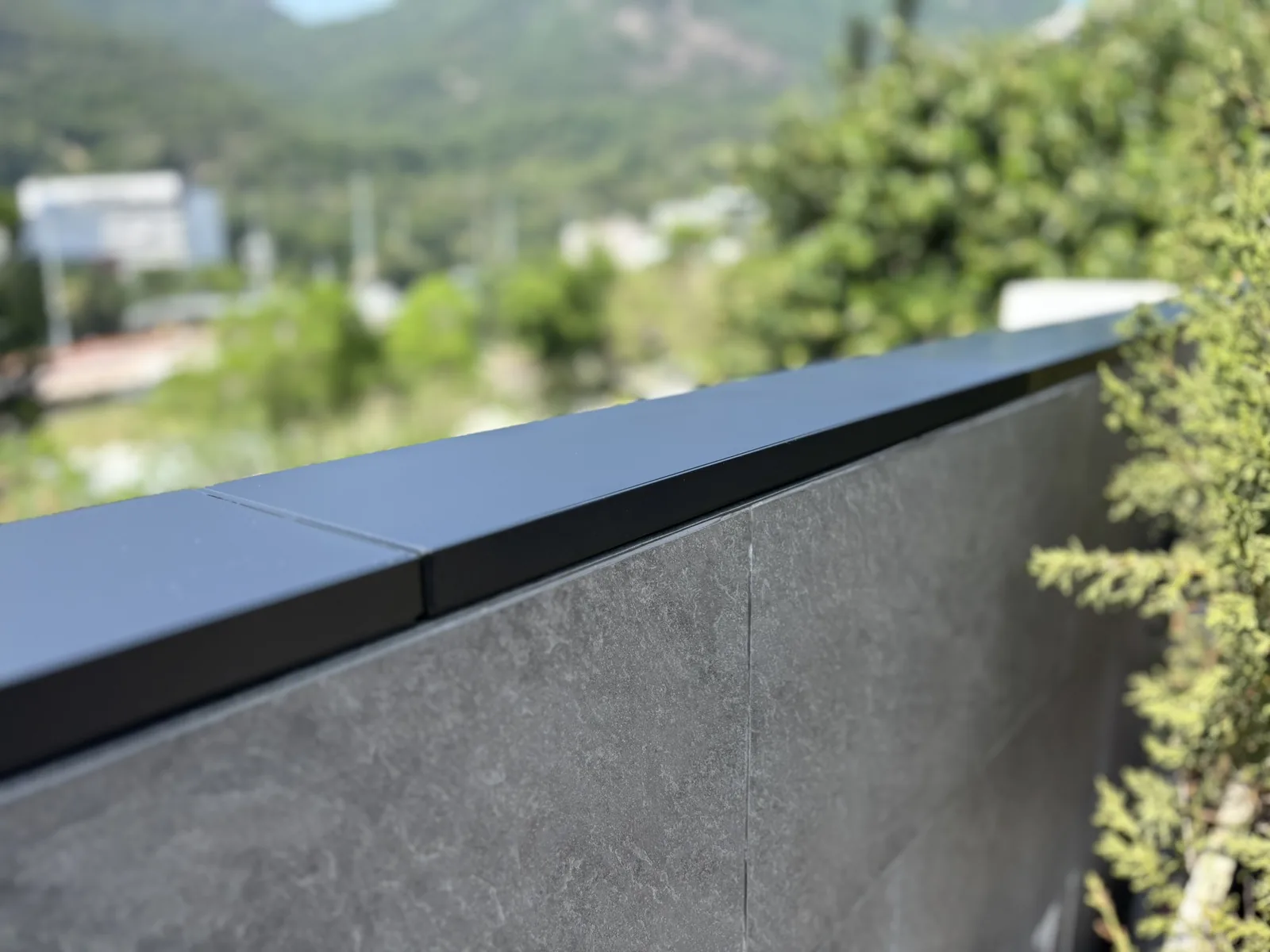 Apeiron Guard matte-black wall-top sensor installed as a low-profile architectural line on a residential wall